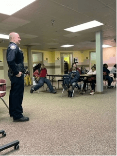 a police man talking to a class of students