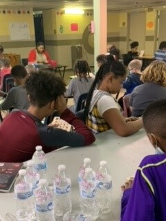 Several students sitting at a table and listening