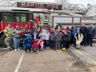 A group of children posing in front of the Martin Fire Department Fire Truck