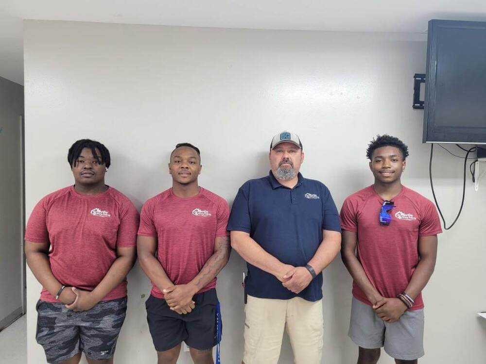 Four men posing and smiling