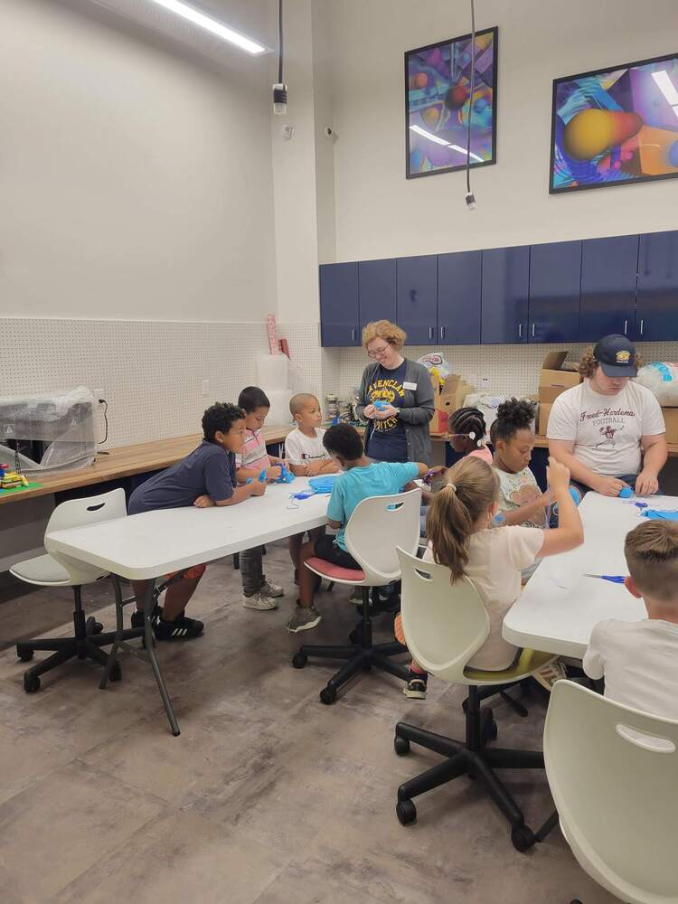 A group of children in a classroom gathered around a table