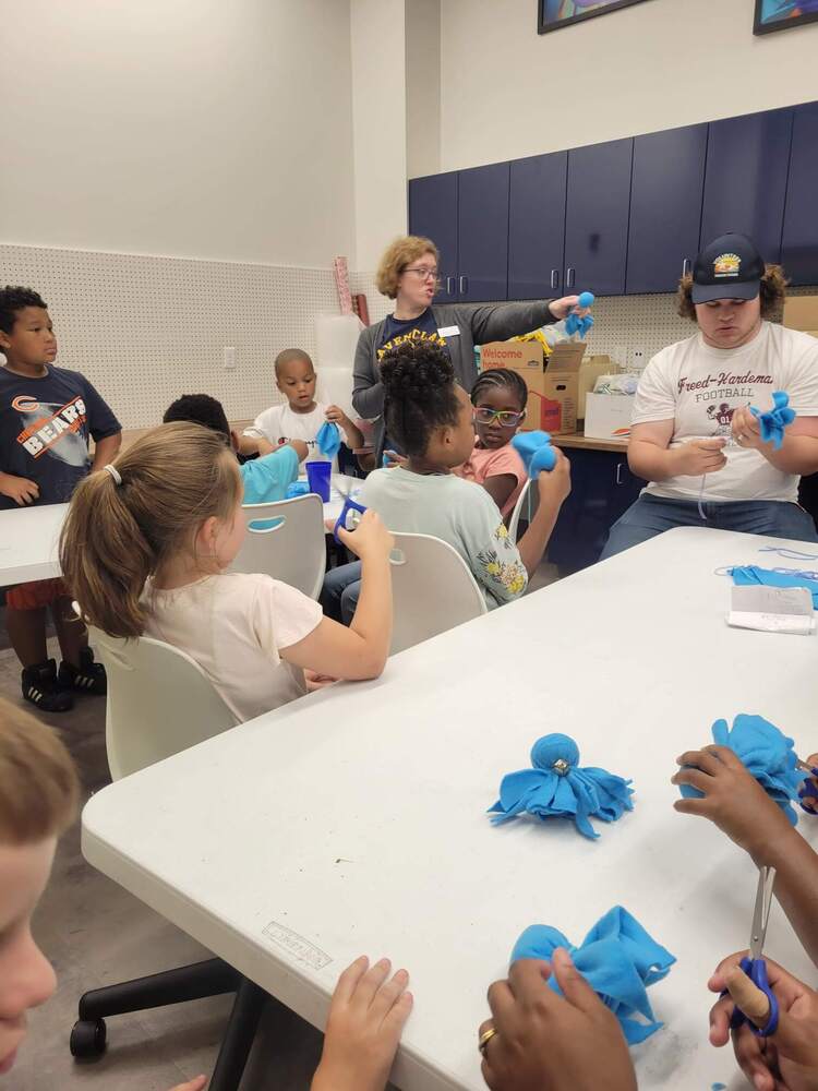 A group of children cutting fabric