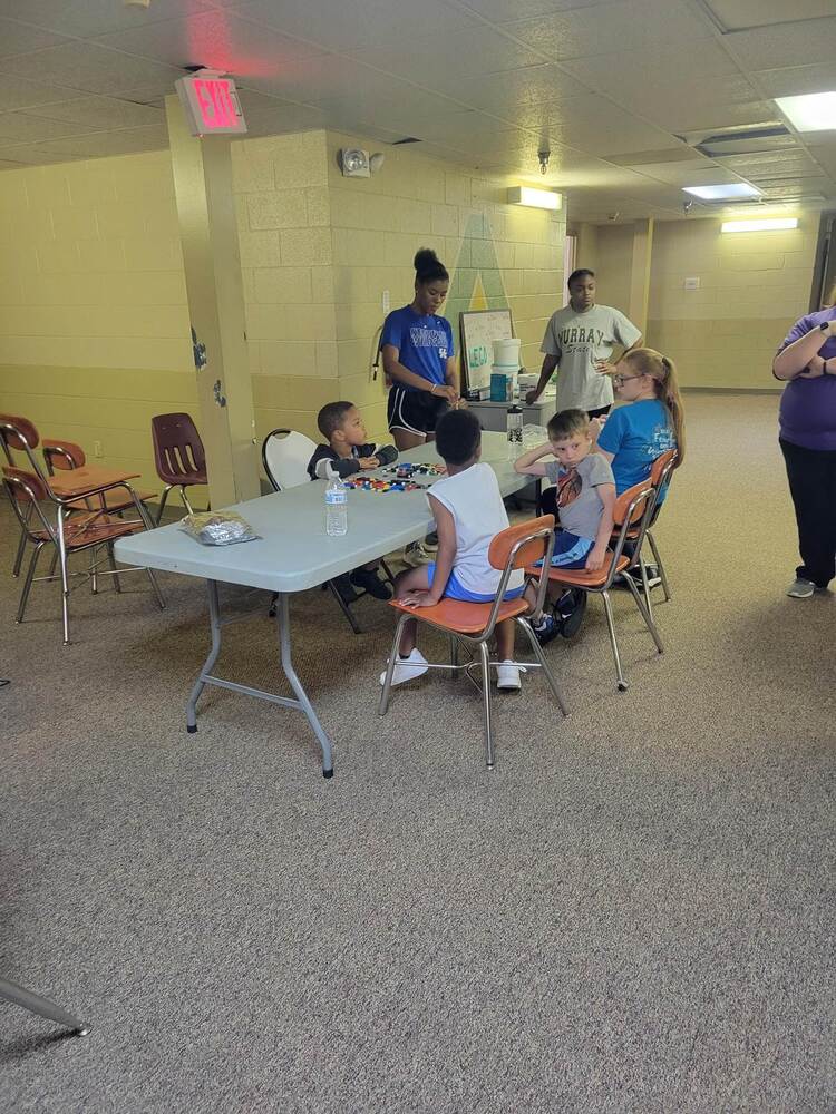 A group of children in a classroom sitting at a table