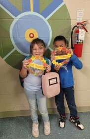 Two young children posing with their handmade wreaths.