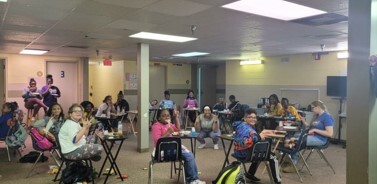 A large group of children sitting in a classroom.