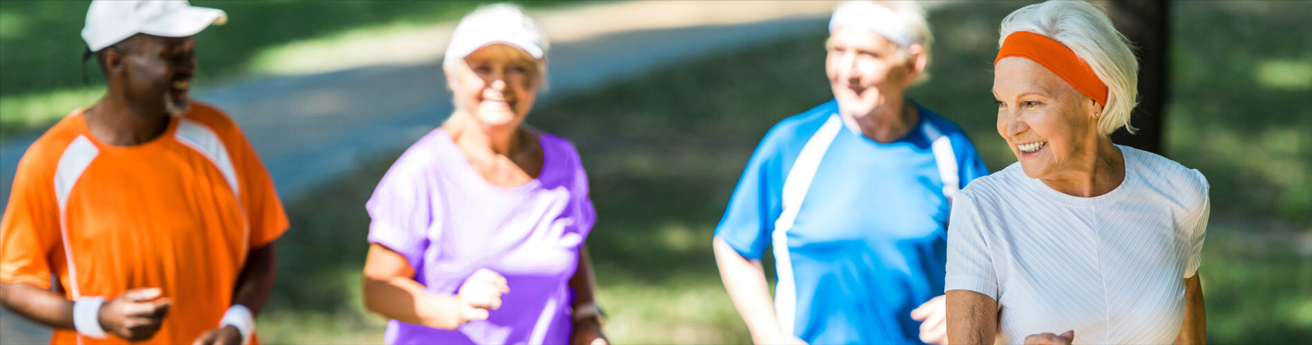 A group of four elderly people going for a jog outdoors.