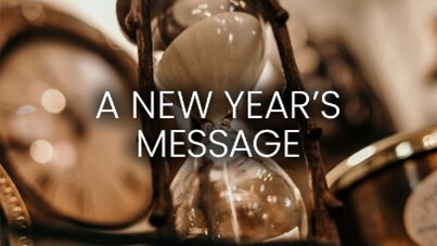 A New Years Message in front of an hourglass.