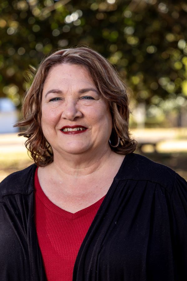 Carla Vowell smiles a bright and happy smile for her headshot.